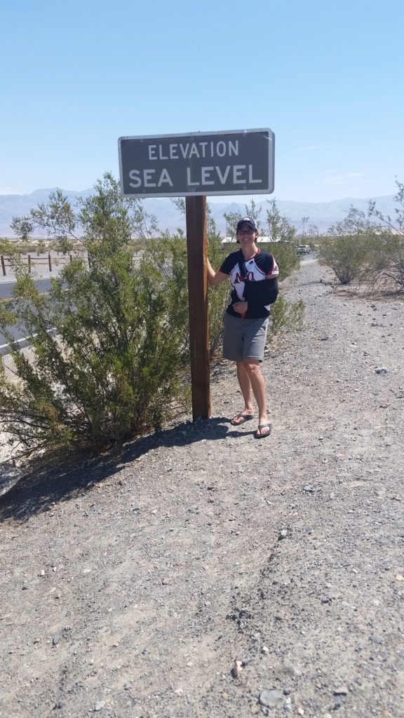 Coach Nicole at a sea level sign outside of Stovepipe Wells in Death Valley National Park, California