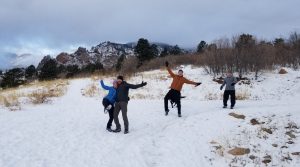 people with open arms on a snowy trail