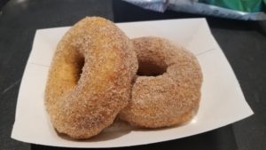 Two cinnamon sugar coated donuts in a paper tray.