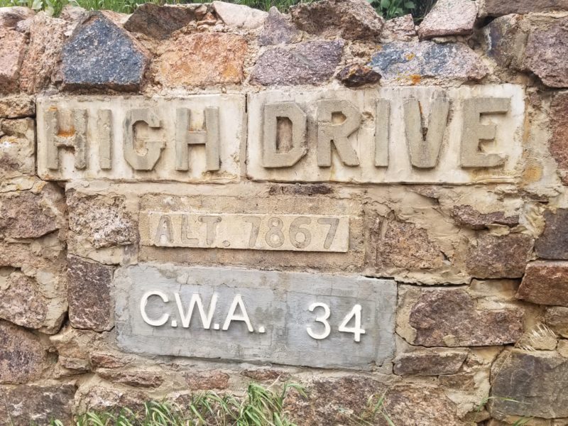 rock wall with concrete signs reading 'HIGH DRIVE' 'ALT 7867' 'C.W.A 34'