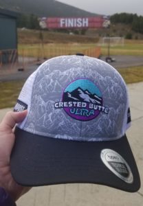 Trucker hat with the Crested Butte Ultra logo with the Finish line blurry in the background.