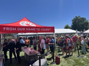 A red Left Hand Beer tent with a line of people waiting to be served.